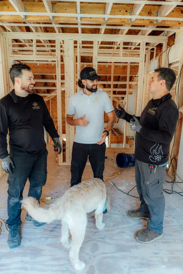 Prime crew discussing a job inside a framed house