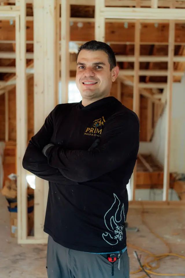 Prime technician standing in a framed room under construction