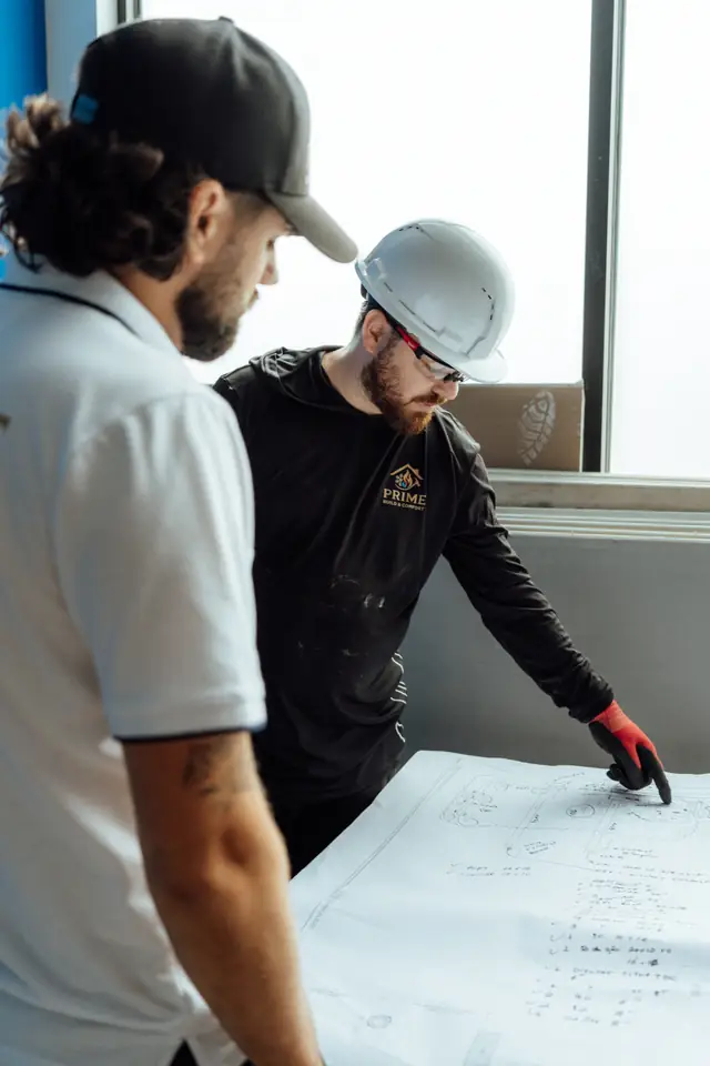 Prime technicians reviewing blueprints on site