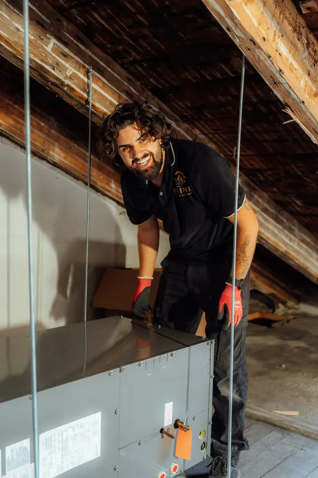 Prime technician smiling during an attic air handler installation