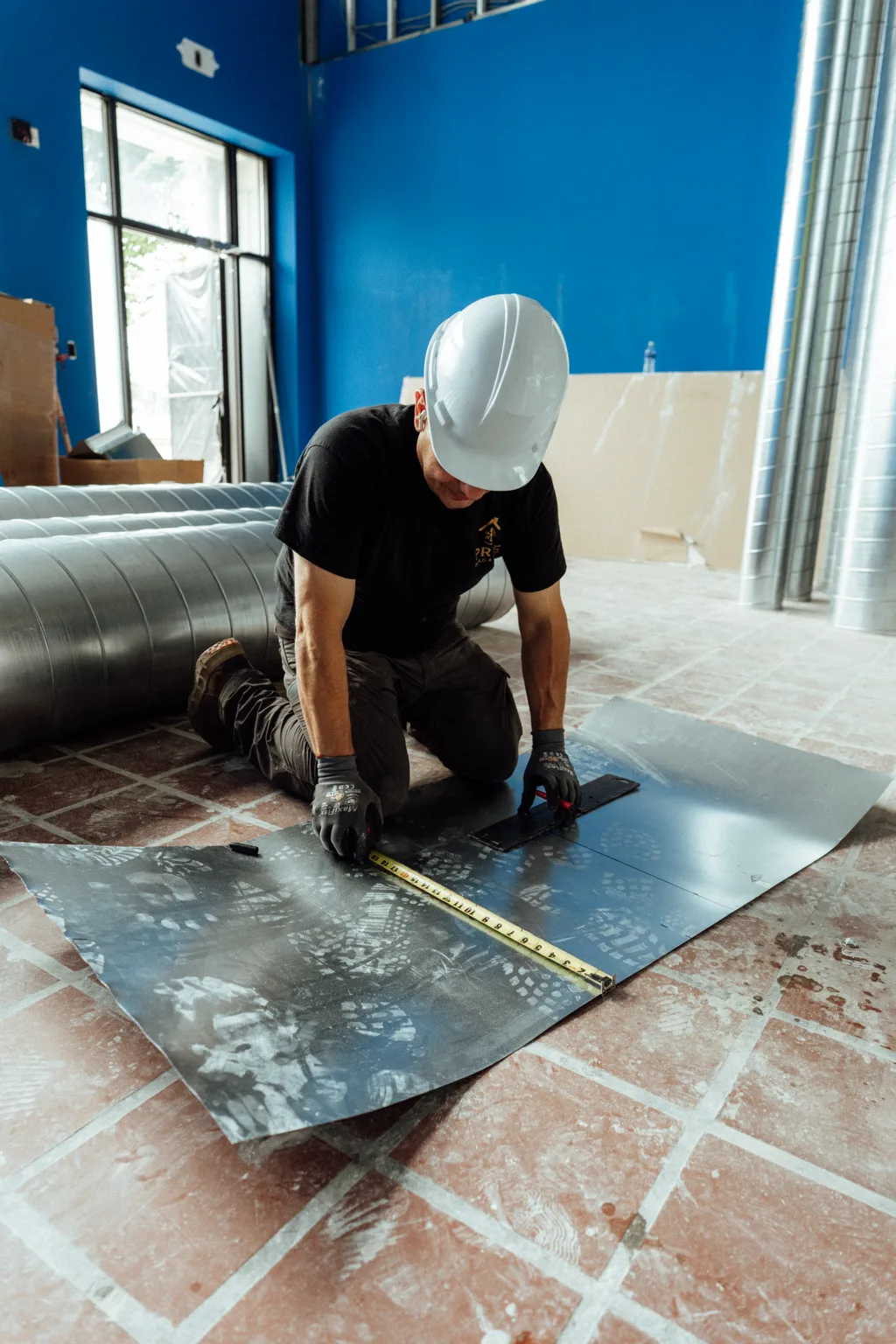 A Prime technician cutting sheet-metal ductwork for a heating install