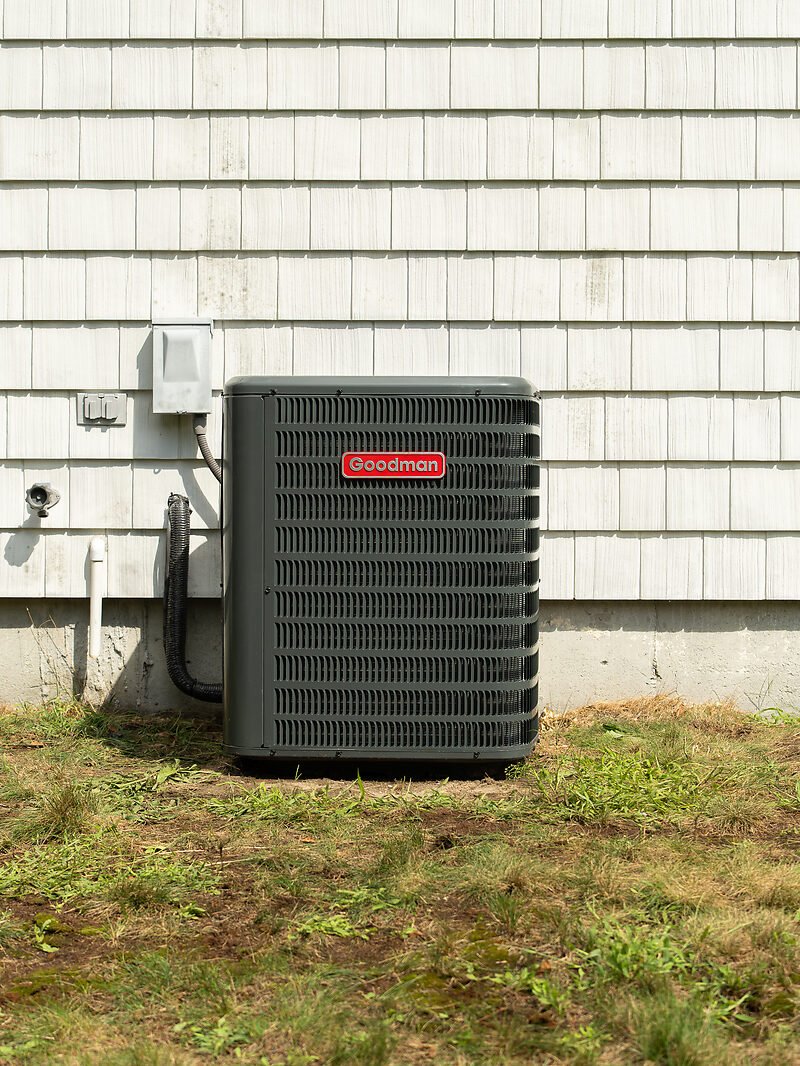 A new, clean outdoor heat pump unit after replacement at the same South Shore home