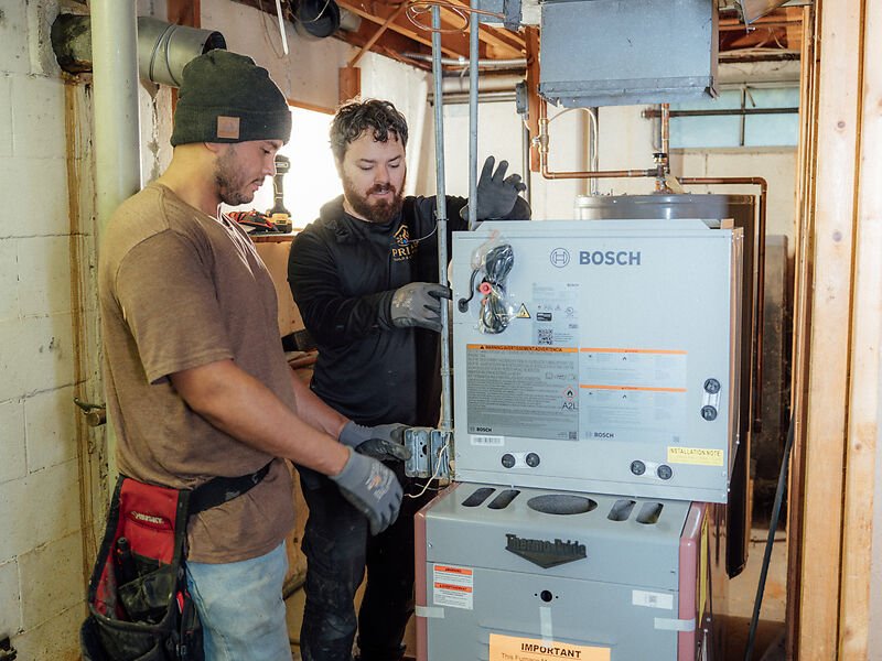 Two Prime technicians installing a new high-efficiency furnace