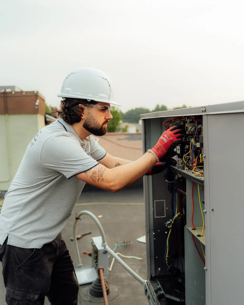 Prime technician on a rooftop unit in a hard hat